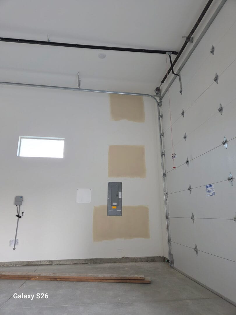 Finished garage wall with fuse box after drywall repair
